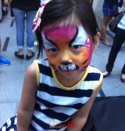 A little girl had a colorful cat face paint at a corporate event in Paterson street