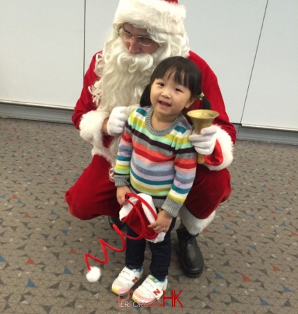 red santa costume with young girl at the airport