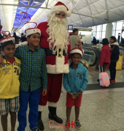 santa in red costume at the airport with kids 