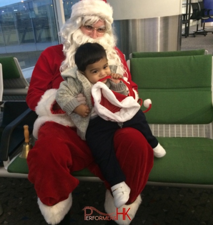 kid sitting on Santas lap at the airport 