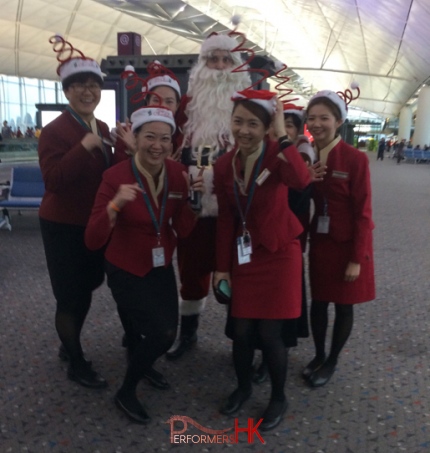 Santa in red costume at the airport with cathay pacific staffs