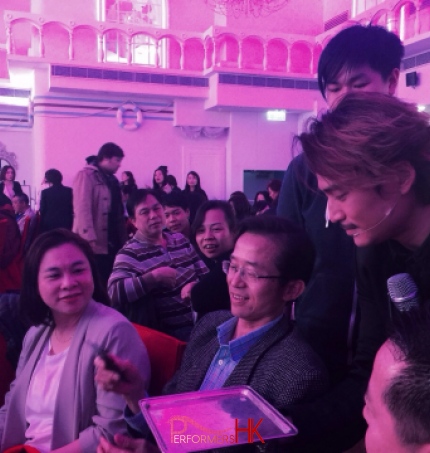 Hong Kong magician is is borrowing a mobile form the gentlemen to finish his stage magic at a corporate annual dinner