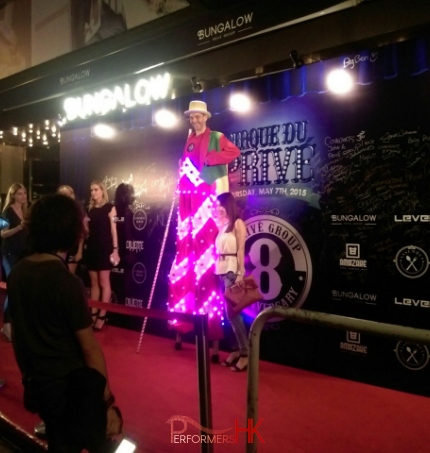 Led stilt walker standing outside nightclub in Hong Kong with model