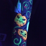 Patron at night club in Hong Kong with body glow in the dark face paint.