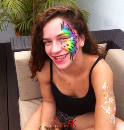 The lady is showing off her new rainbow color peafowl pattern face paint which draw by a HK talented face painter at a corporate function