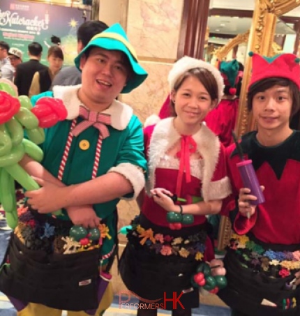 Three HK roving balloons artist dressed as Elf and Santa girl at a corporate Christmas dinner