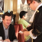 Joker performing strolling magic to a patron at a french themed event in Hong Kong.