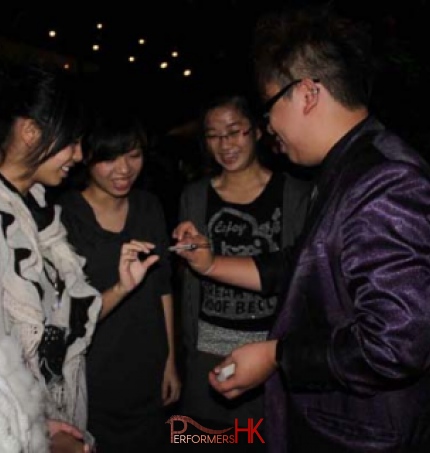 Hong Kong magician performing roving magic to four girls standing