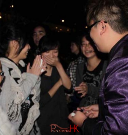 Magician performing roving magic to four girls at a Hong Kong Bank corporate cocktail event.