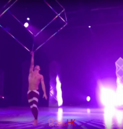 Acrobat spinning a giant steel cube above his head