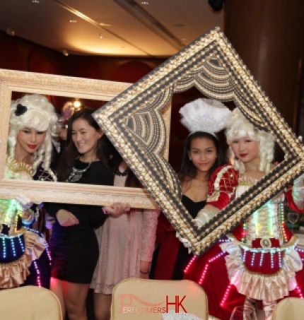 Two pretty girls wearing courtesan style costume with LEDs and having pictures taken with large photos frames