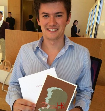 Male client in blue shirt holding portrait cut out at Cartier event 