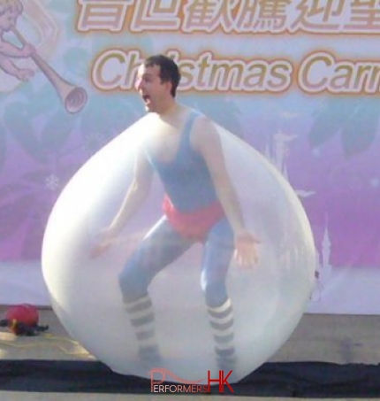 Juggler performing his famous trick , getting inside the giant balloon act at a Hong Kong Christmas Carnival