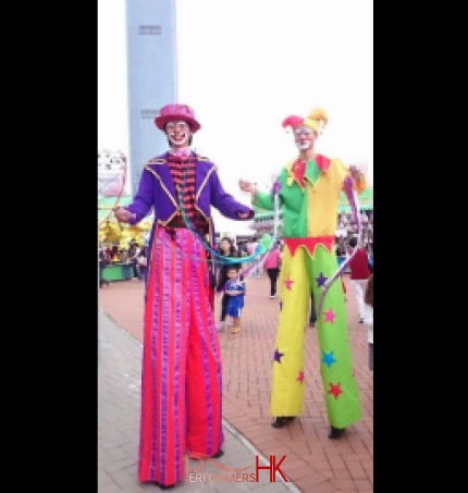 Two stilt walkers performing poi tricks 