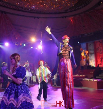 Stiltwalker and juggler and pretty girl in parade in the Hyat Hong Kong ballroom