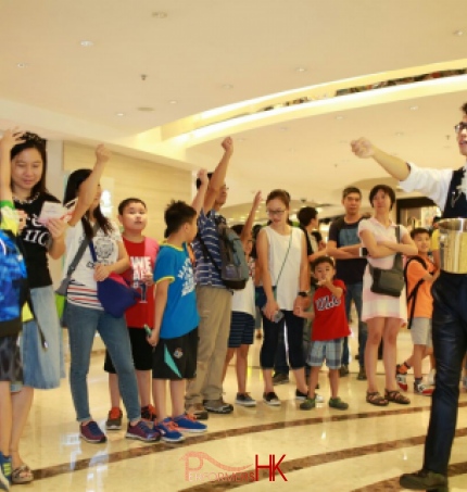 Roving magician performing coins magic at a corporate shopping mall event in Hong Kong 