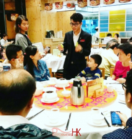 Walk around magician performing table magic for a family to promote the new menu at a Hong Kong restaurant  
