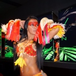 Dancer performing with snakes wrapped around her arms.