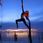 Female aerial sills performer shows her flexibility and grace under the sunset. 