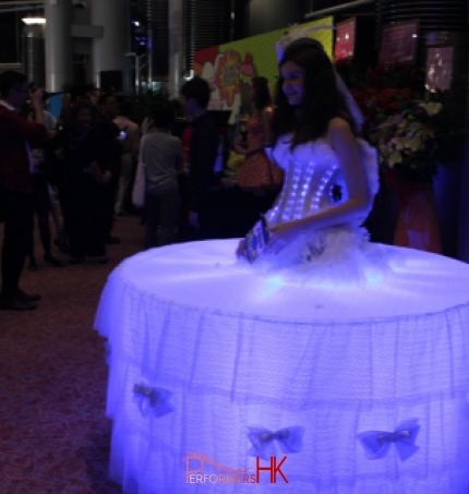 Model dressed in LEd lights and standing in the middle of a table