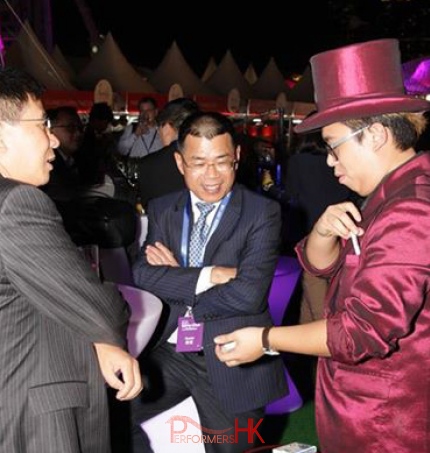 Walk-around magician performing to two gentlemen at a race meet in Hong Kong