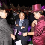 Walk-around magician performing to two gentlemen at a race meet in Hong Kong