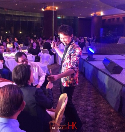 Roving magician in Hong Kong performing roving magic to CEO with wine at annual dinner