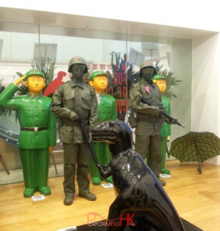 Two toy solder living statues staning next to three green army at a Hong Kong store opening event