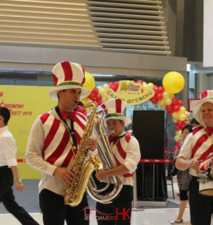 Three strolling musicians wearing colorful candy cane vests in a mall