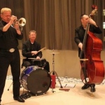 Three live band musicians performing at a Hong Kong realistic opening event