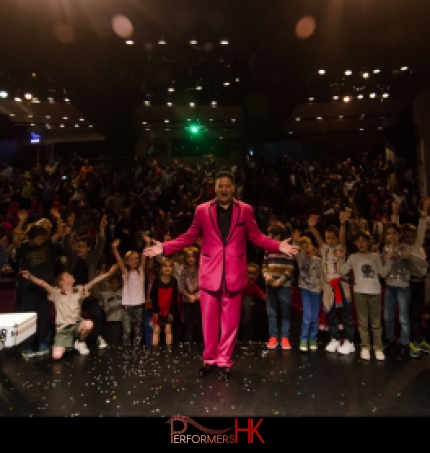 Hong Kong stage magician taking a picture with his audience after his performance at a corporate children event 
