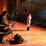 Hong Kong singer performing with a live band on stage at a Annual dinner