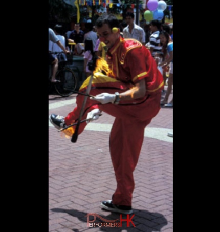 Hong Kong juggler juggling Fire Devil stick under his leg at a corporate event