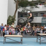 Shaun the trail biker jumps from one table to another as he stands up on his bike.