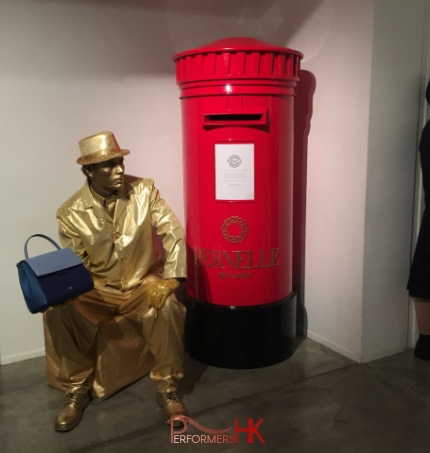 Living Statue holding handbag sitting next to red post box in hong kong