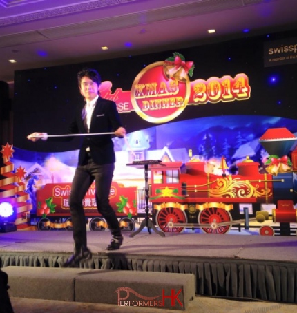 Magician performing stage magic with rope in front of a train backdrop at Hong Kong Swiss Privilege Christmas Dinner