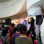 Wing performing needle through a balloon magic trick on stage. 