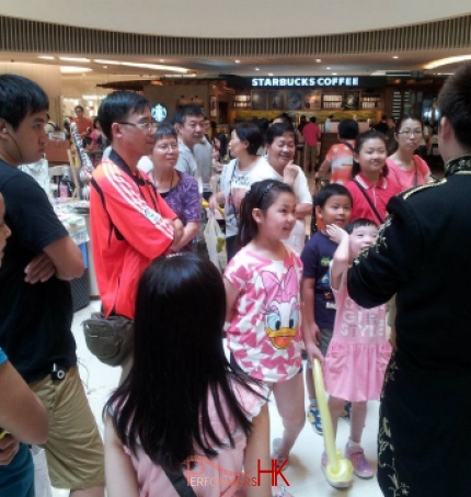 Magician with crowd around him at shopping mall