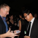 Shaun setting his card magic trick up with a guests at a cocktail function about to be awed. 