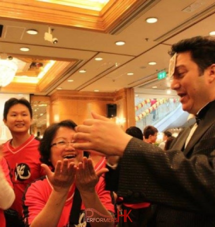 magician performing roving card magic to runner at the Li & Fung Standard Chartered Hong Kong Marathon after party in Regal Hotel