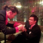 Roving magician performing coins trick  to CEO at DBS Hong Kong cocktails event 