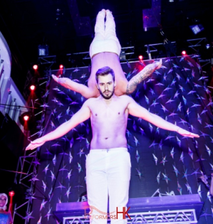 Two adage performers performing duo act at a corporate club event,one of the Performer upside down and holding by other performer with his shoulder only