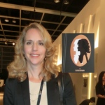 Business lady next to her portrait cutout at an exhibition