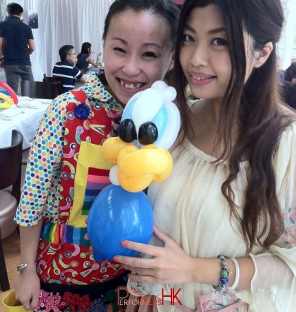 Hong Kong walk around balloons artist twisted a cartoon character balloons to a lady at corporate event
