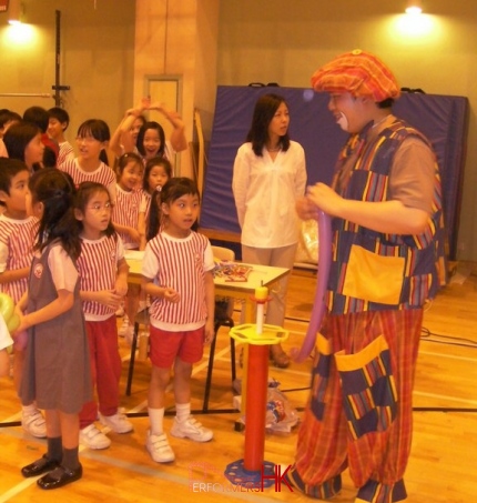 Student in Hong Kong all lined up to get a balloon from the balloon clown at a corporate school event