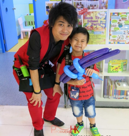 Walk around balloon twister twisted a blue and purple gun to a kid at a Hong Kong Corporate store opening event