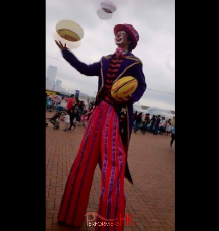 Two stilt walkers juggling rugby at a Hong Kong corporate event