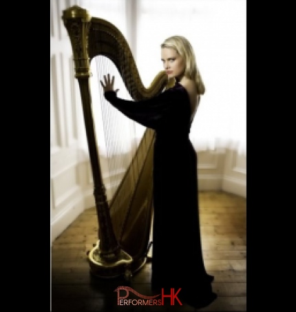 A HK harpist wearing a black dress posing next with the harp for a wedding