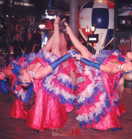 4 can can dancers lifting leg and pointing to sky together 