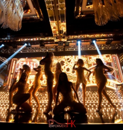 dancers on stage with gold background for crazy horse them event